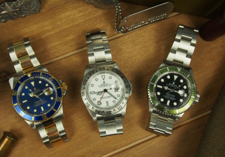 3 ROlex watches on wooden background with bullet