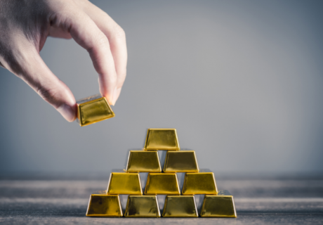 man stacking gold bullion bars in pyramid