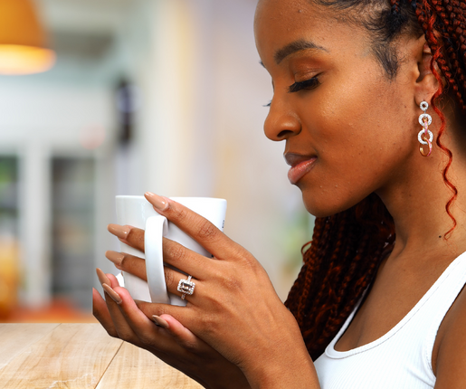 woman with coffee mug with jewelry on thinking of questions about jewelry