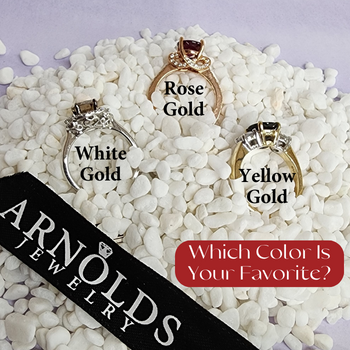 White gold yellow gold and rose gold rings laying in white rocks with Arnold Jewelers Ribbon
