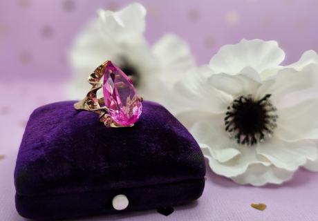 pink gemstone ring lab sapphire on top of ring box with white flowers